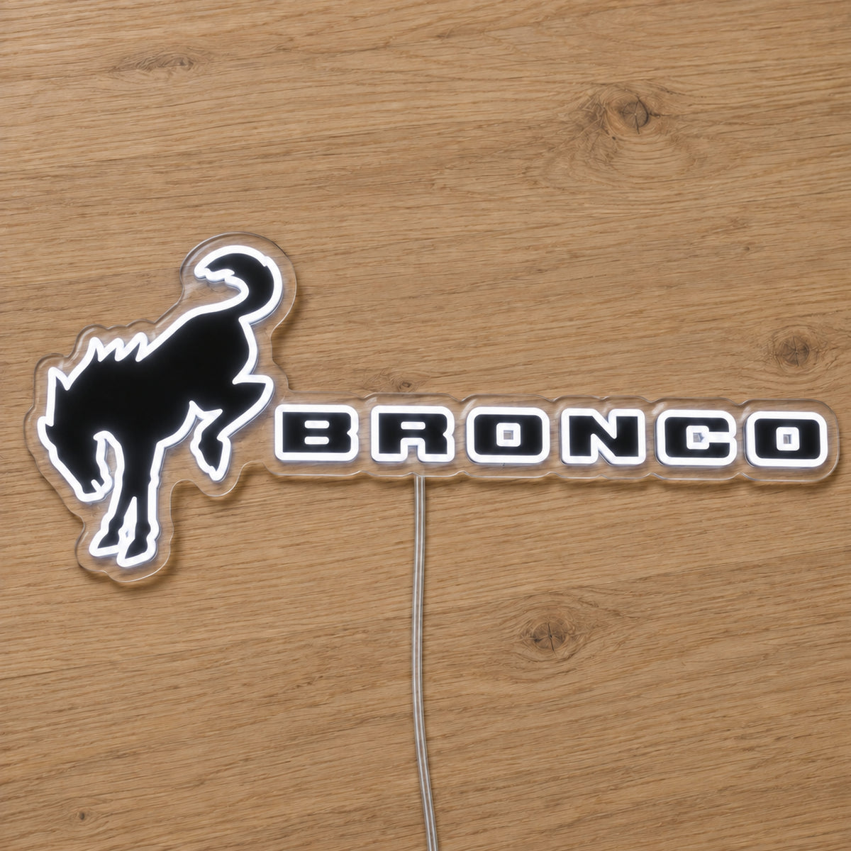 Ford Bronco LED Neon Sign, featuring illuminated vehicle logo on a wooden surface.