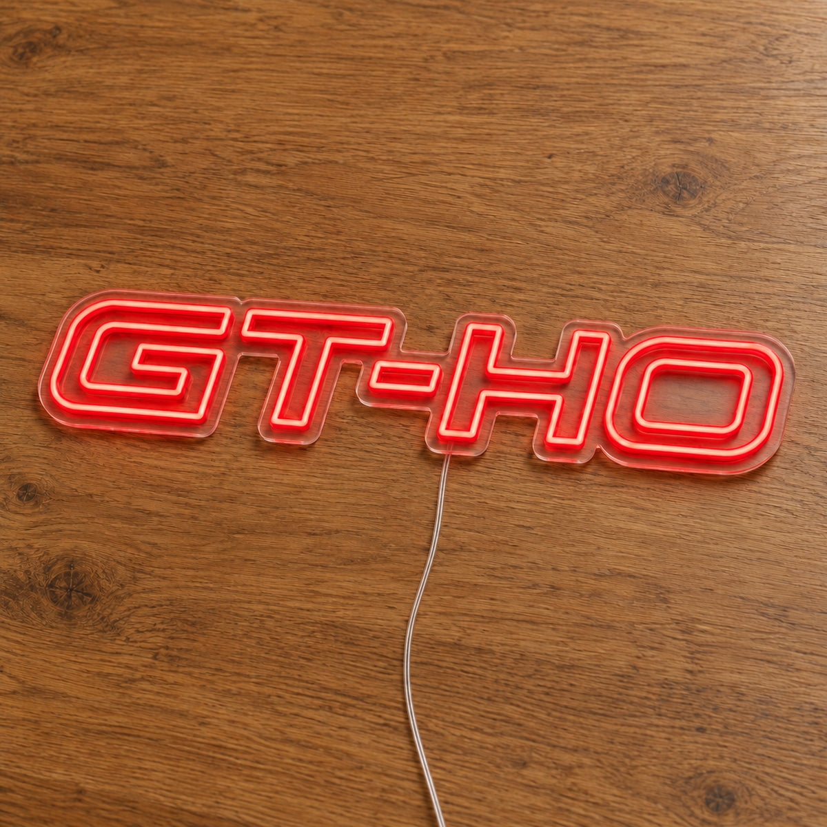 GT-HO LED Neon Sign in red, featuring GT-HO lettering on a wooden surface.