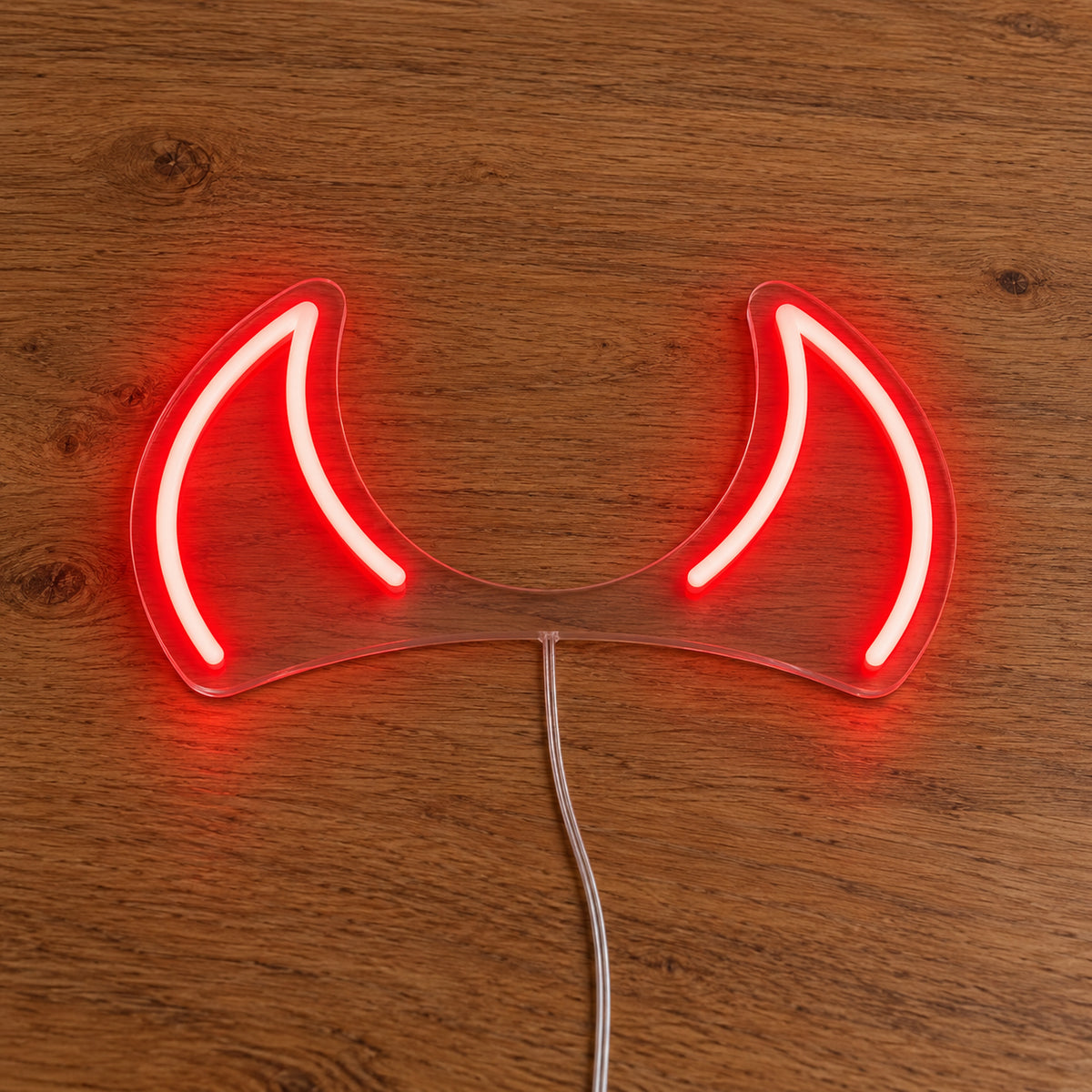 Horns LED Neon Light Sign in red, featuring pair of devil-horn outlines on a wooden surface.