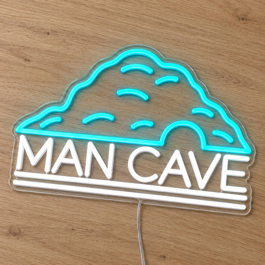 Man Cave Neon Sign - Garage & Home Bar Wall Sign in turquoise and white, featuring a cave outline above Man Cave lettering on a wooden surface.