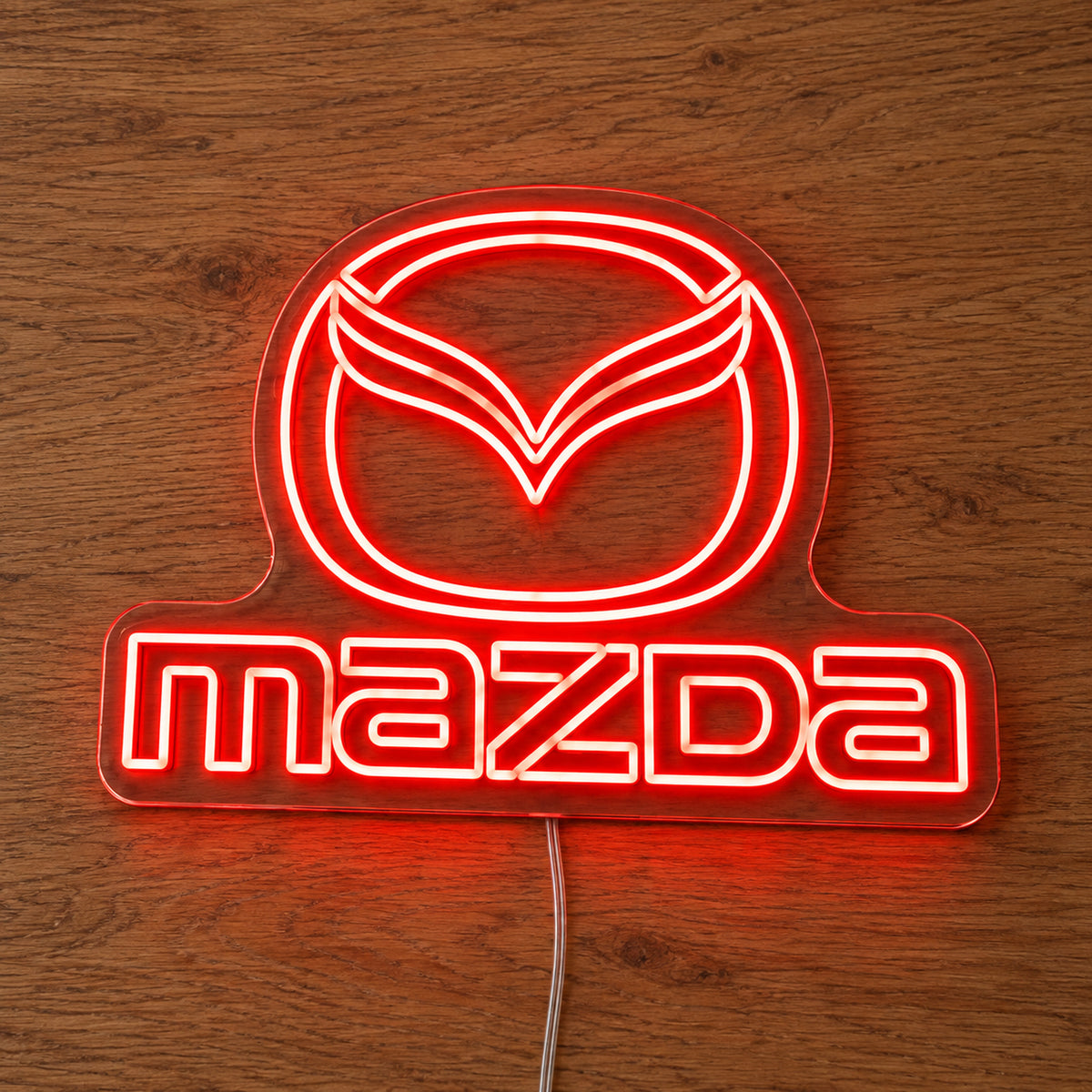 Mazda Logo LED Neon Sign in red, featuring Mazda emblem and lettering on a wooden surface.