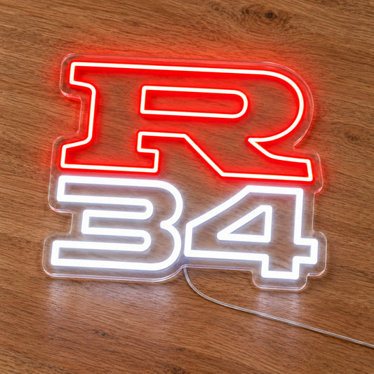 Nissan R34 LED Neon Sign in red and white, featuring R34 lettering on a wooden surface.