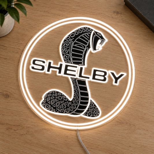 Shelby Cobra LED Neon Sign, featuring illuminated vehicle logo on a wooden surface.