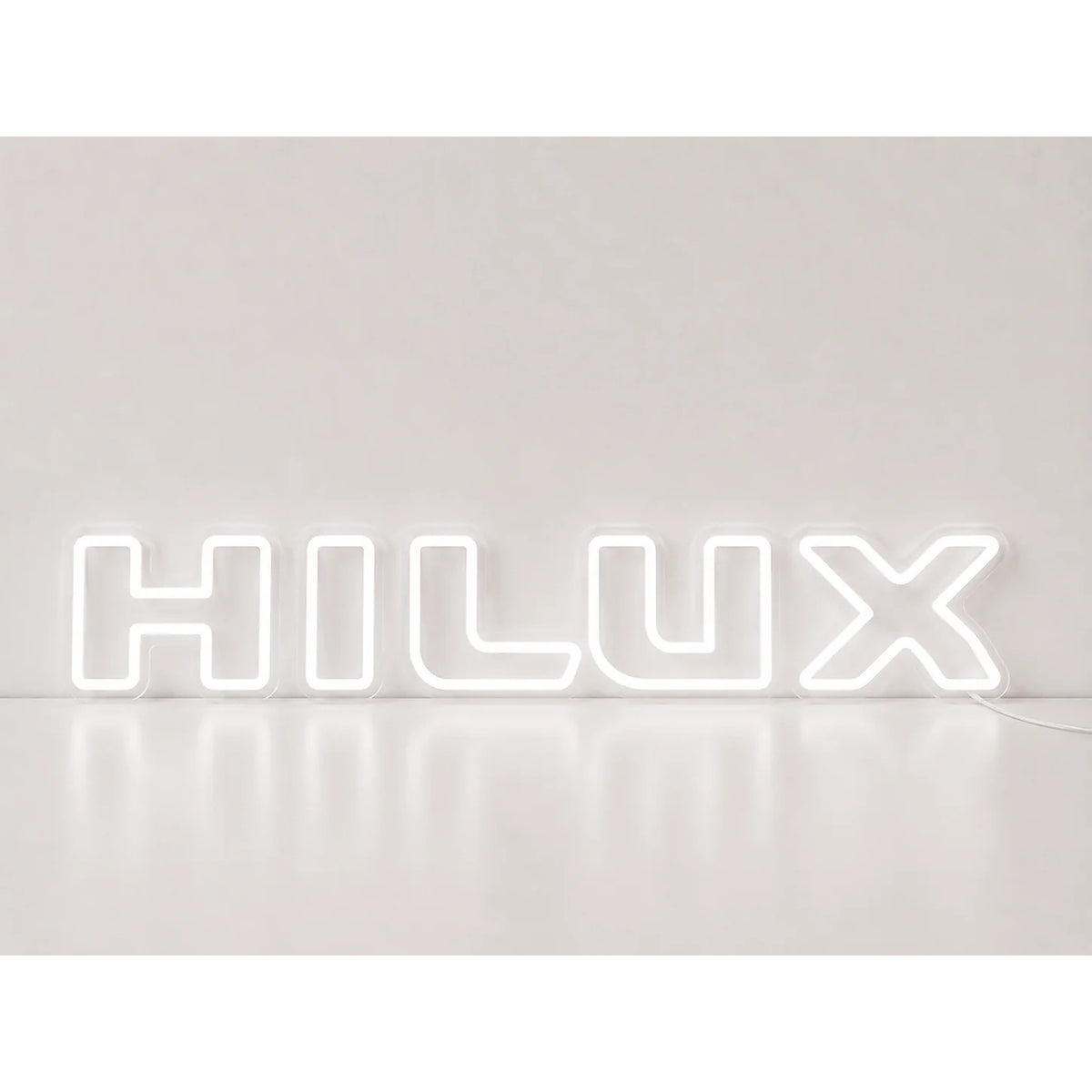 Toyota Hilux Neon Sign in white, featuring Hilux lettering on a light wall.