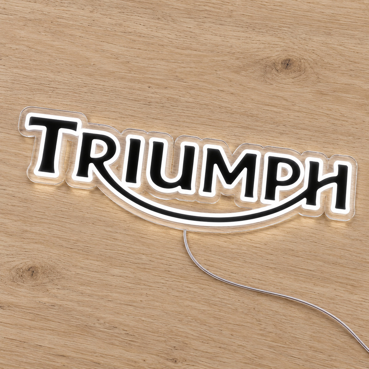 Triumph LED Neon Sign, featuring illuminated vehicle logo on a wooden surface.