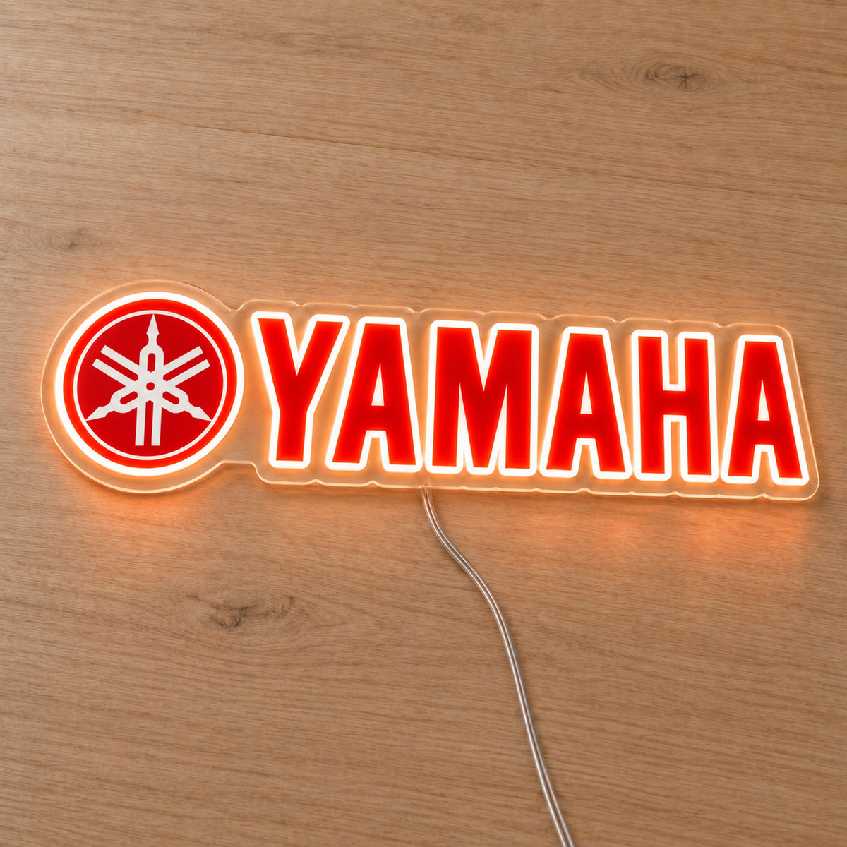 Yamaha (Emblem Logo) LED Neon Sign, featuring illuminated vehicle logo on a wooden surface.