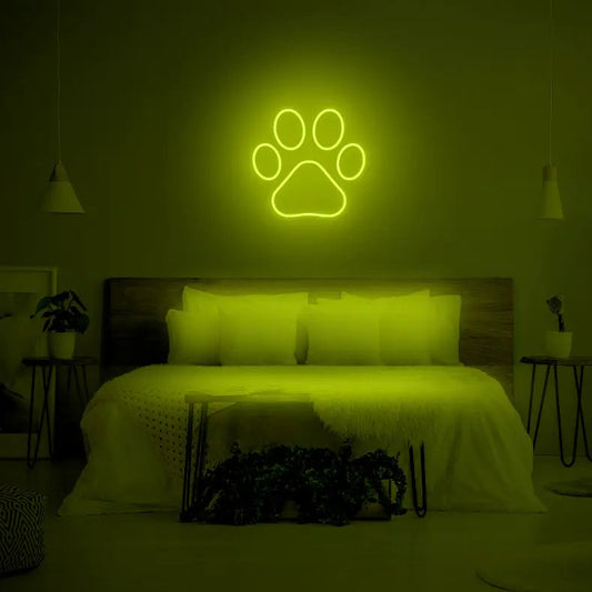 Paw LED Neon Light Sign in green, featuring paw-print outline illuminated above a bed.