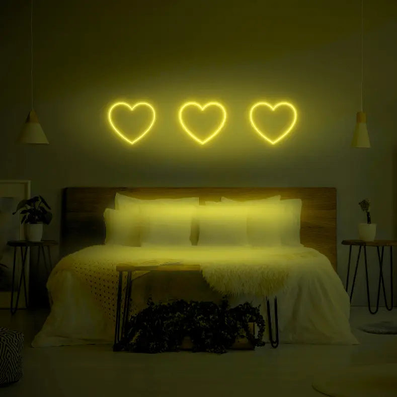 3 Hearts LED Neon Light Sign in lime green, featuring three heart outlines illuminated above a bed.