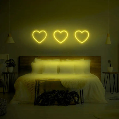 3 Hearts LED Neon Light Sign in lime green, featuring three heart outlines illuminated above a bed.