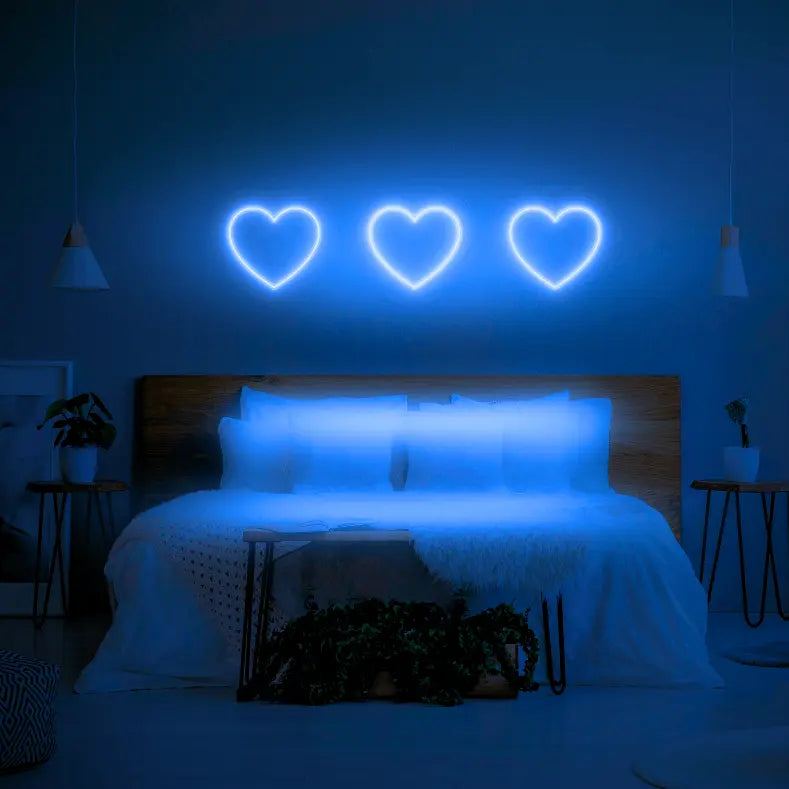 3 Hearts LED Neon Light Sign in blue, featuring three heart outlines illuminated above a bed.