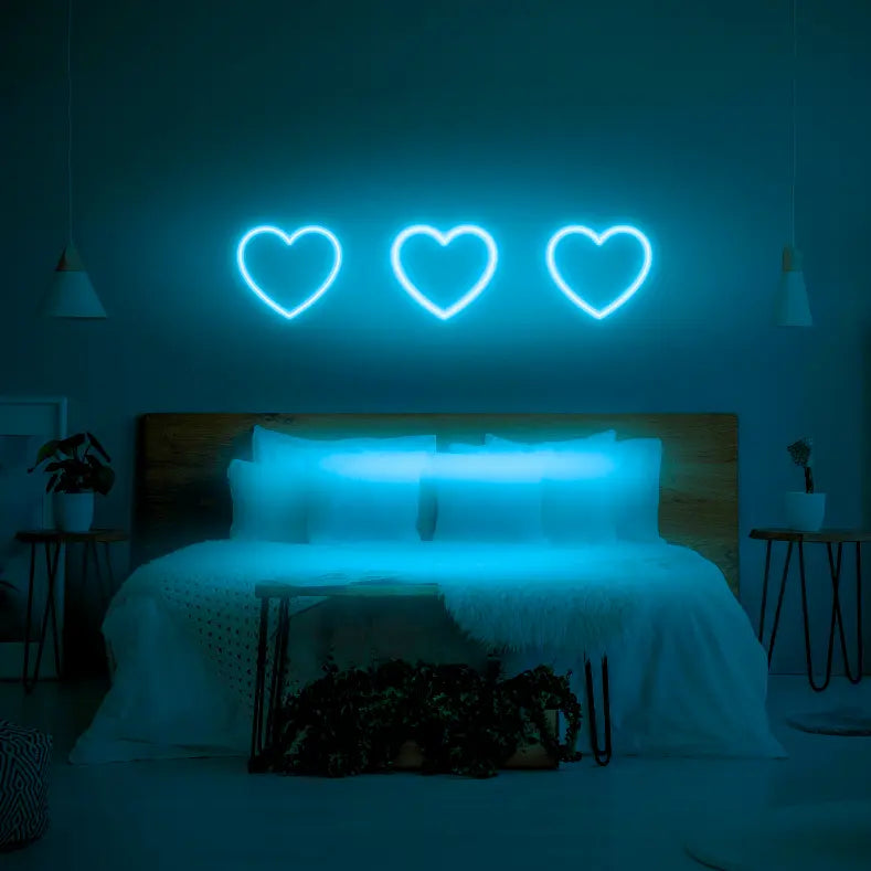 3 Hearts LED Neon Light Sign in light blue, featuring three heart outlines illuminated above a bed.