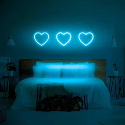 3 Hearts LED Neon Light Sign in light blue, featuring three heart outlines illuminated above a bed.