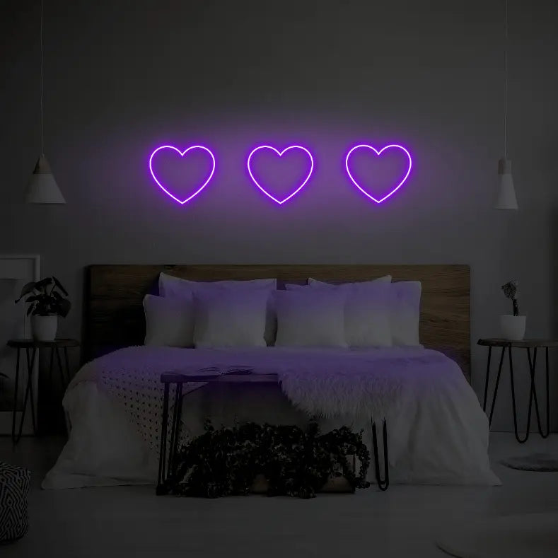 3 Hearts LED Neon Light Sign in purple, featuring three heart outlines illuminated above a bed.