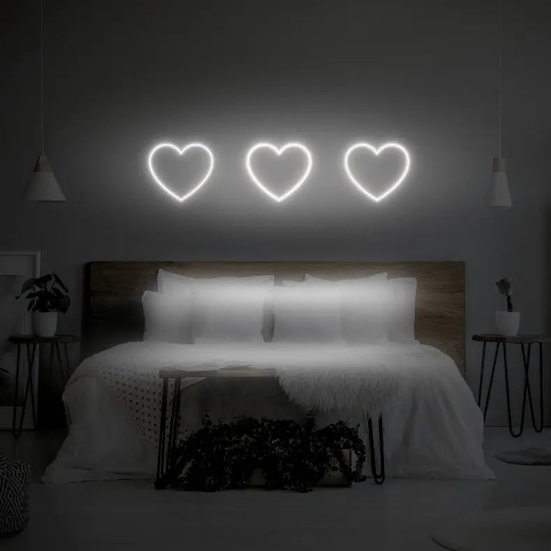 3 Hearts LED Neon Light Sign in white, featuring three heart outlines illuminated above a bed.
