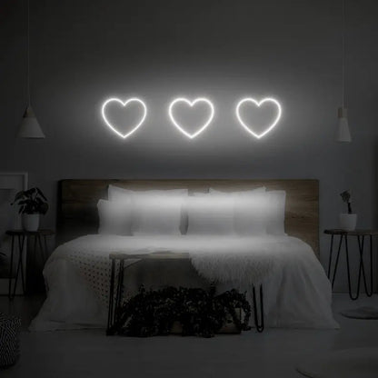 3 Hearts LED Neon Light Sign in white, featuring three heart outlines illuminated above a bed.