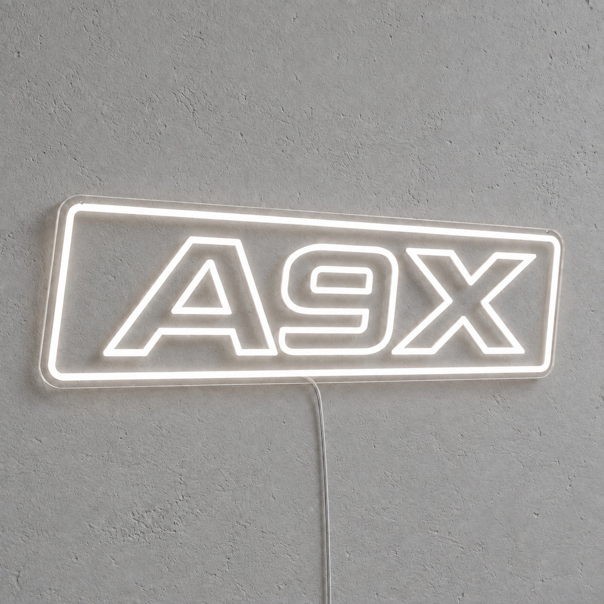 A9X Torana LED Neon Sign in white, featuring A9X lettering inside a rectangular border on a grey wall.