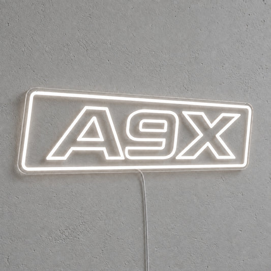 A9X Torana LED Neon Sign in white, featuring A9X lettering inside a rectangular border on a grey wall.