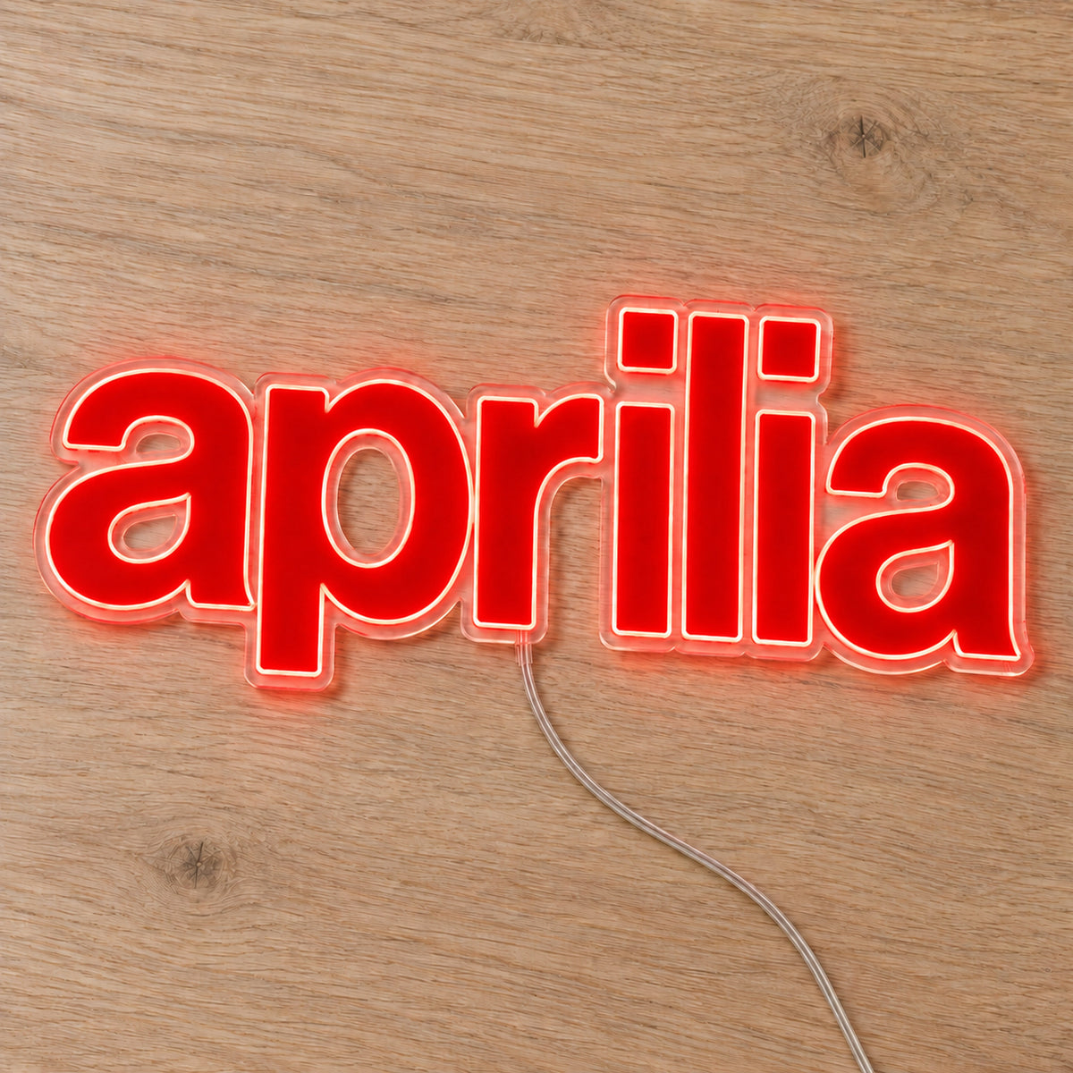 Aprilia LED Neon Sign, featuring illuminated vehicle logo on a wooden surface.