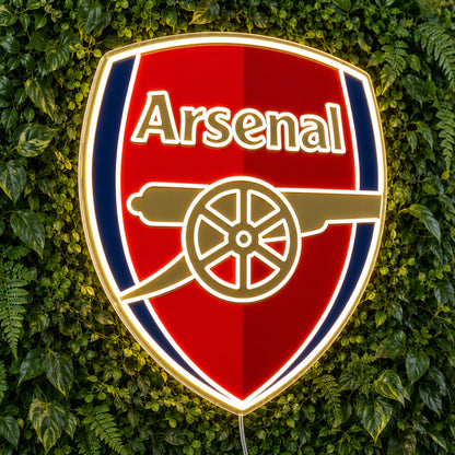 Arsenal LED Neon Sign, featuring team logo displayed on a green foliage wall.