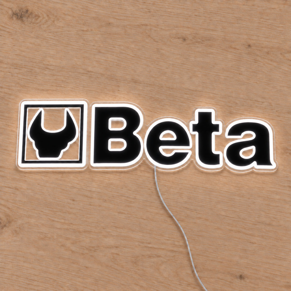 Beta LED Neon Sign, featuring illuminated vehicle logo on a wooden surface.