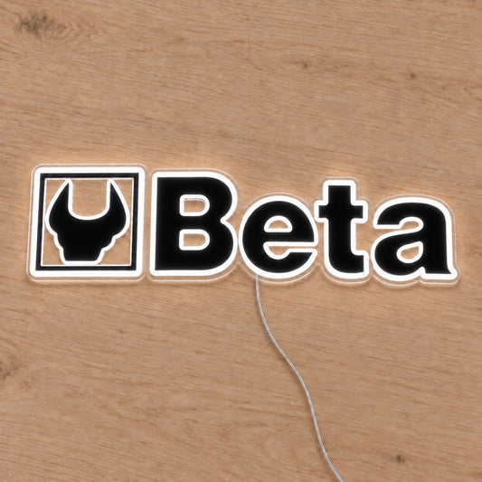 Beta LED Neon Sign, featuring illuminated vehicle logo on a wooden surface.
