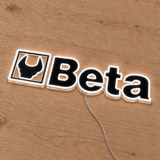 Beta LED Neon Sign, featuring illuminated vehicle logo on a wooden surface viewed at an angle.