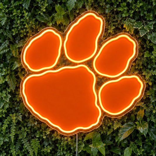 Clemson Tigers Paw LED Neon Sign, featuring team logo displayed on a green foliage wall.