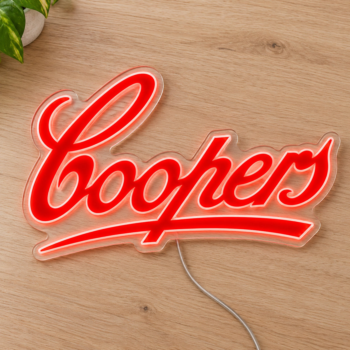 Coopers LED Neon Sign, featuring illuminated beer-brand logo on a wooden surface.