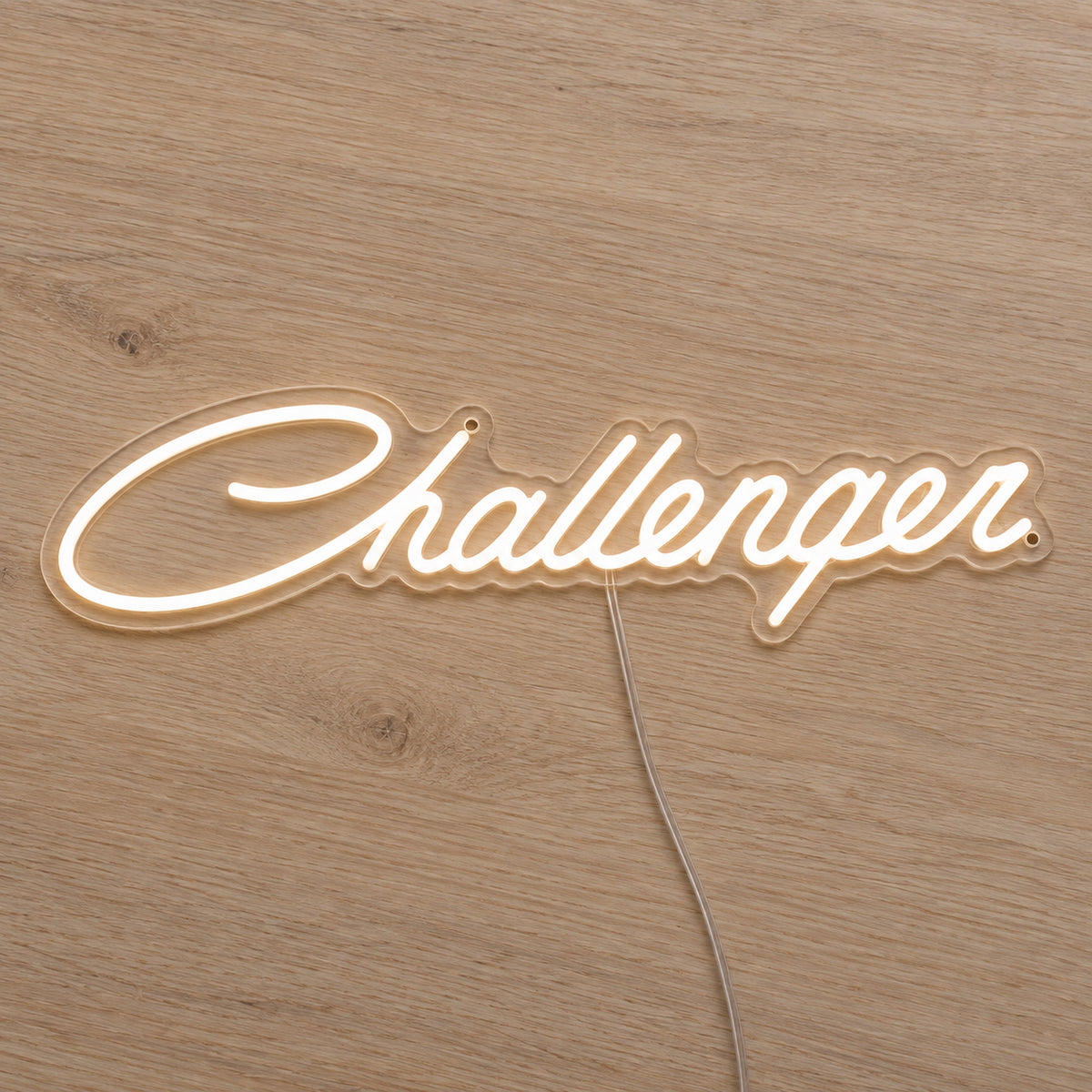 Dodge Challenger LED Neon Sign in warm white, featuring Challenger script lettering on a wooden surface.