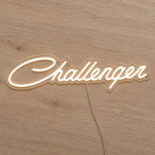 Dodge Challenger LED Neon Sign in warm white, featuring Challenger script lettering on a wooden surface.