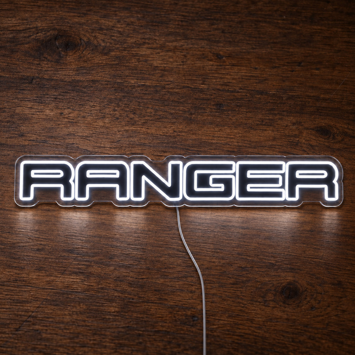 Ford Ranger LED Neon Sign in white, featuring Ranger lettering on a wooden surface.