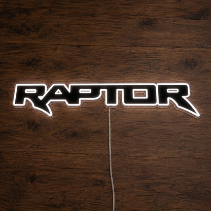 Ford Ranger Raptor LED Neon Sign in white, featuring outlined Raptor lettering on a wooden surface.