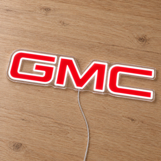 GMC LED Neon Sign, featuring illuminated vehicle logo on a wooden surface.
