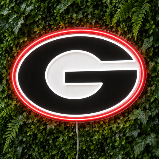 Georgia Bulldogs LED Neon Sign, featuring illuminated team logo on a green foliage wall.