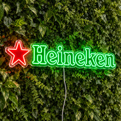 Heineken LED Neon Sign, featuring beer-brand logo displayed on a green foliage wall.
