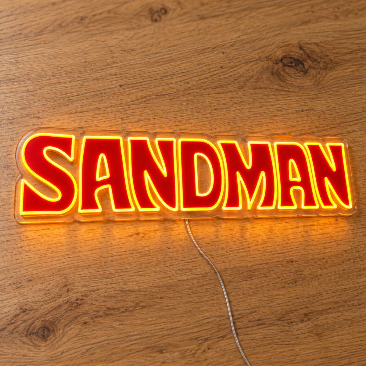 Holden Sandman Style LED Neon Sign in red and yellow, featuring Sandman lettering on a wooden surface.