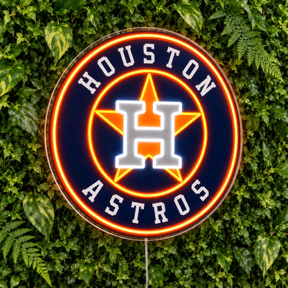 Houston Astros LED Neon Sign, featuring illuminated team logo on a green foliage wall.