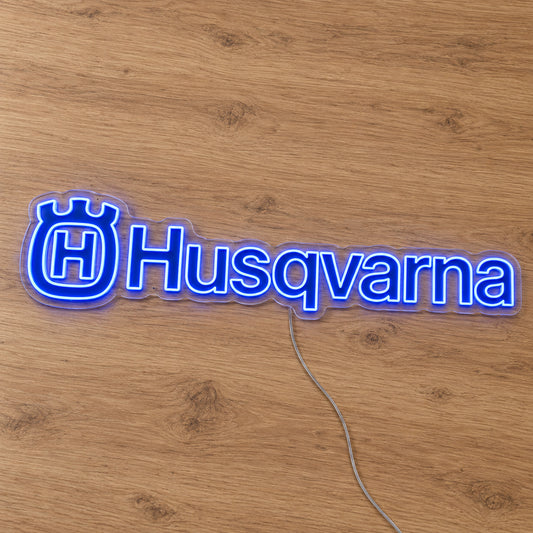 Husqvarna LED Neon Sign, featuring illuminated vehicle logo on a wooden surface.