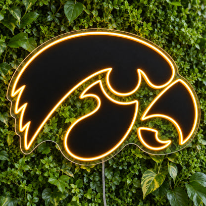 Iowa Hawkeyes LED Neon Sign, featuring team logo displayed on a green foliage wall.