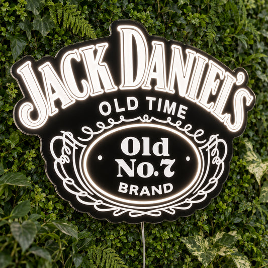 Jack Daniels LED Neon Sign, featuring illuminated brand logo on a green foliage wall.