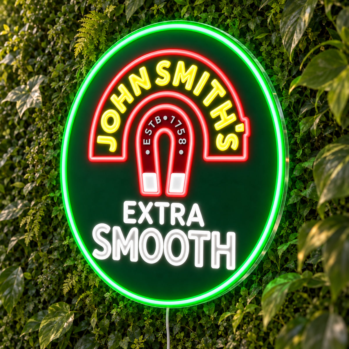 John Smith's LED Neon Sign, featuring beer-brand logo displayed on a green foliage wall.