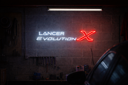 Lancer Evolution LED neon sign glowing in a garage setting, bold JDM performance wall light for car enthusiasts