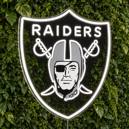 Las Vegas Raiders LED Neon Sign, featuring illuminated team logo on a green foliage wall.
