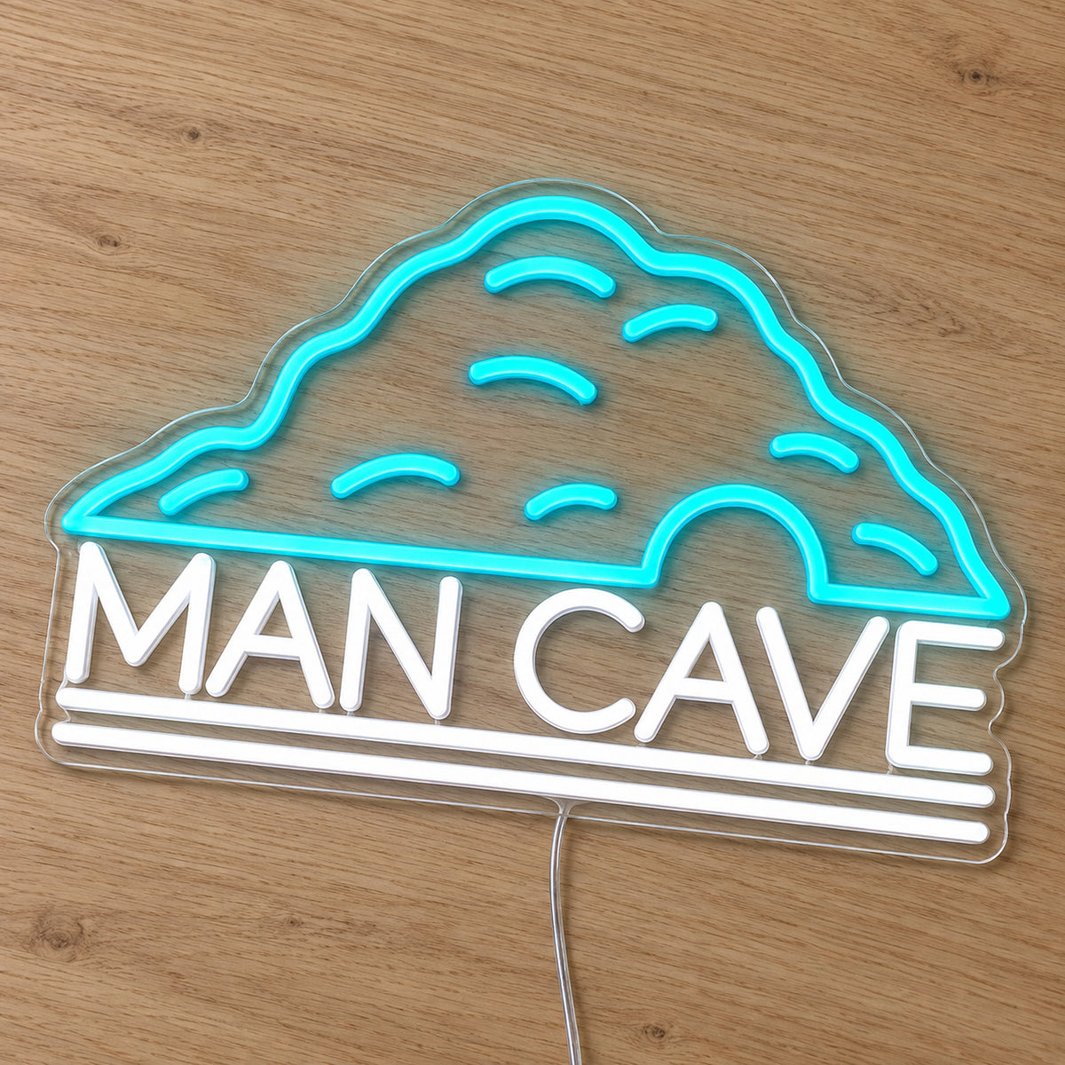 Man Cave Neon Sign - Garage & Home Bar Wall Sign in turquoise and white, featuring a cave outline above Man Cave lettering on a wooden surface.