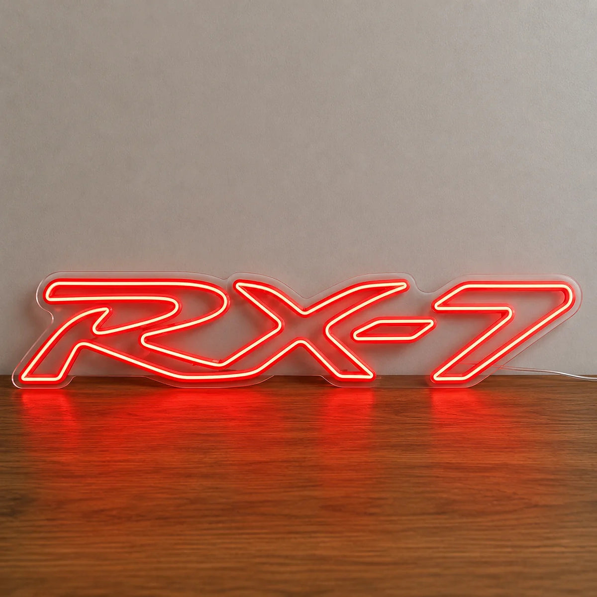 Mazda RX-7 Neon Sign in red, featuring RX-7 lettering standing on a wooden surface.