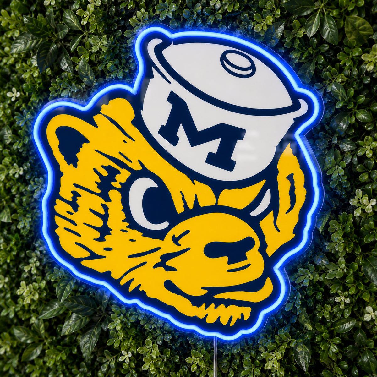 Michigan Wolverines Retro Mascot LED Neon Sign, featuring team logo displayed on a green foliage wall.