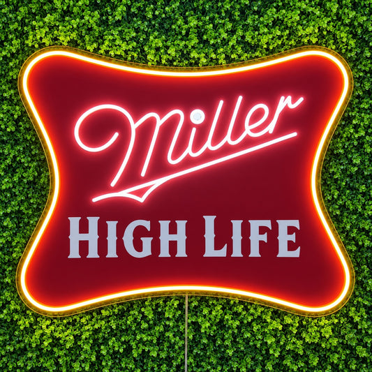 Miller High Life LED Neon Sign, featuring illuminated beer-brand logo on a green foliage wall.