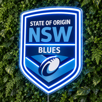 NSW Blues (State of Origin) LED Neon Sign, featuring illuminated team logo on a green foliage wall.