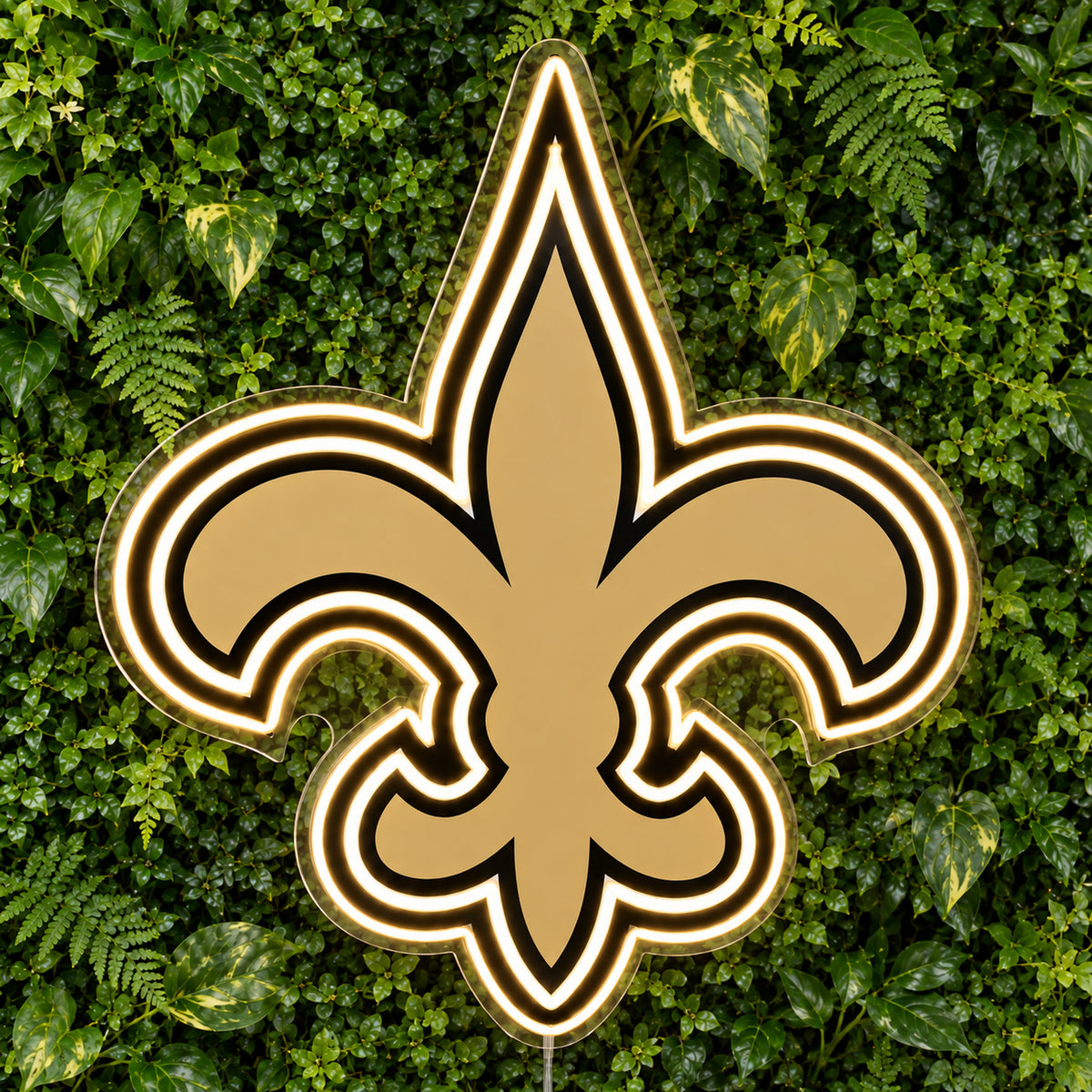 New Orleans Saints LED Neon Sign, featuring illuminated team logo on a green foliage wall.