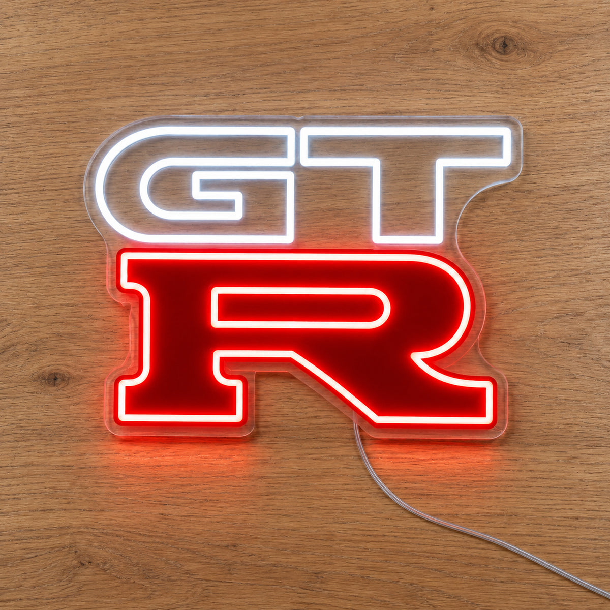 Nissan GTR LED Neon Sign in white and red, featuring GT-R logo on a wooden surface.
